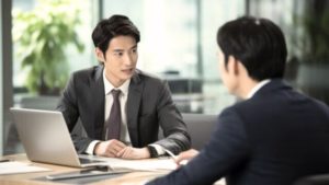 30代の男性ビジネスパーソンが力強く顧客にプレゼンをしている写真